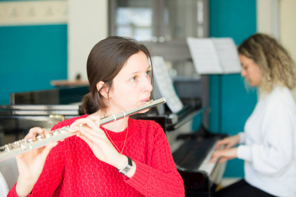 istock Young women playing piano and flute 1135091151