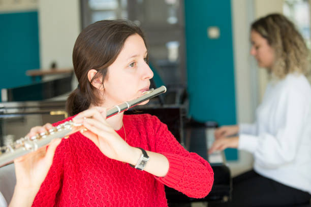 istock Young women playing piano and flute 1135091154
