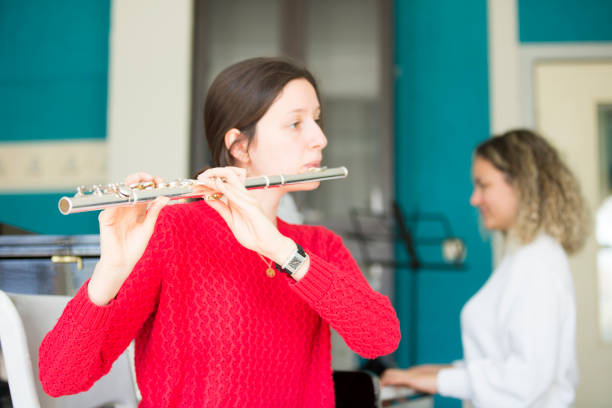 istock Young women playing piano and flute 1135091174