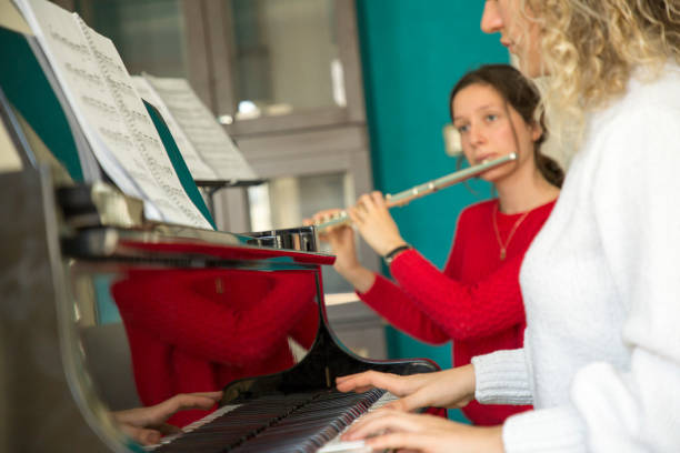 istock Young women playing piano and flute 1135091175