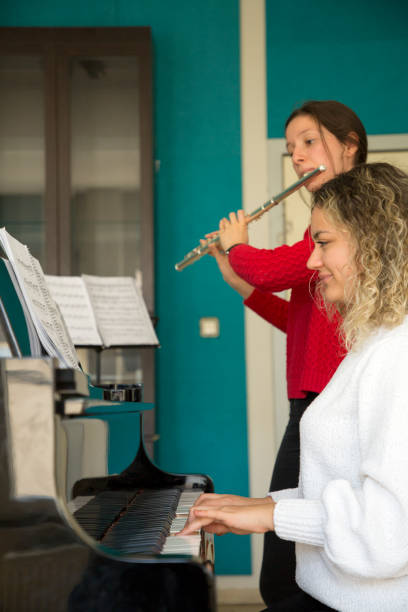 istock Young women playing piano and flute 1135091194