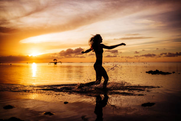 istock Woman walk on the beach on the sunset. 1135091902