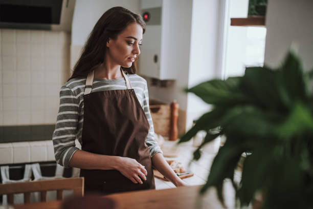 istock Calm young lady is doing chores in kitchen 1135095976