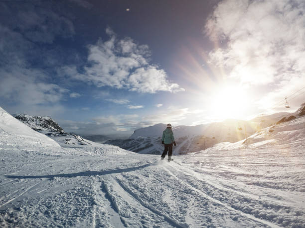 Lady/girl on skis in Norway, she is on the way down a ski slope in brilliant sunshine. Hemsedal
