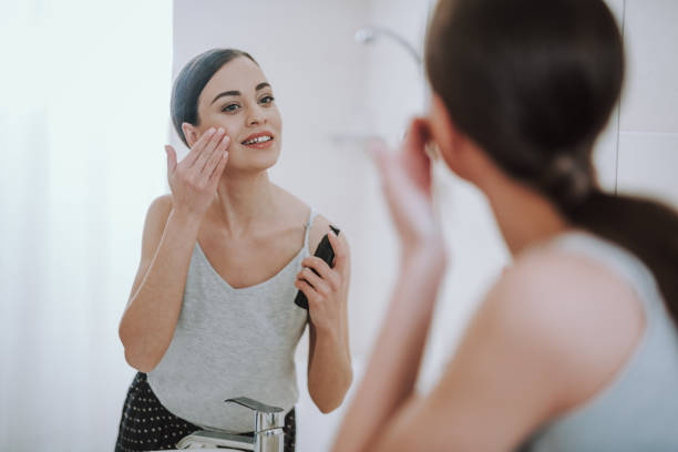 istock Attractive smiling woman using her face gel 1135098509