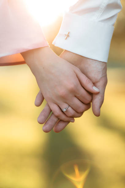 istock young couple holding hands on the arm ring. Close Up view 1135098988
