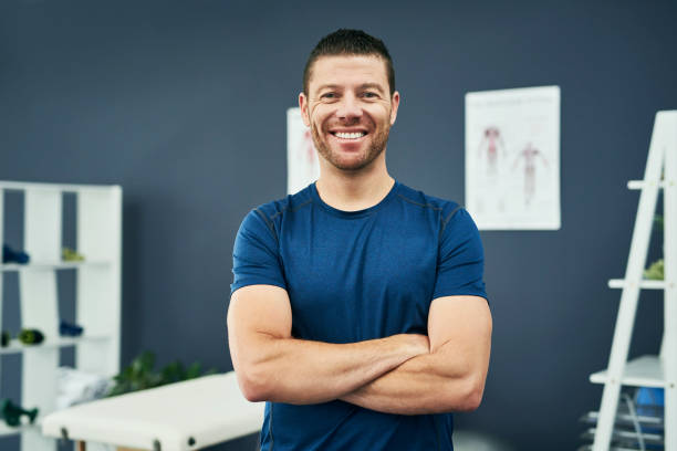 I love doing what I do Cropped portrait of a handsome male physiotherapist standing with his arms folded in his office physical therapist stock pictures, royalty-free photos & images