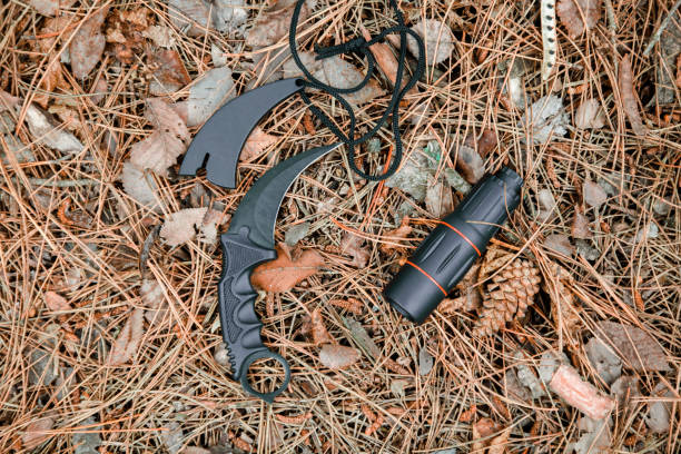 istock monocle and karambit knife on the ground covered with pine needles 1135100759