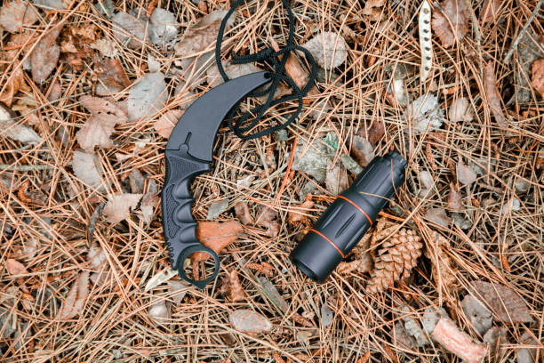 istock monocle and karambit knife on the ground covered with pine needles 1135102445