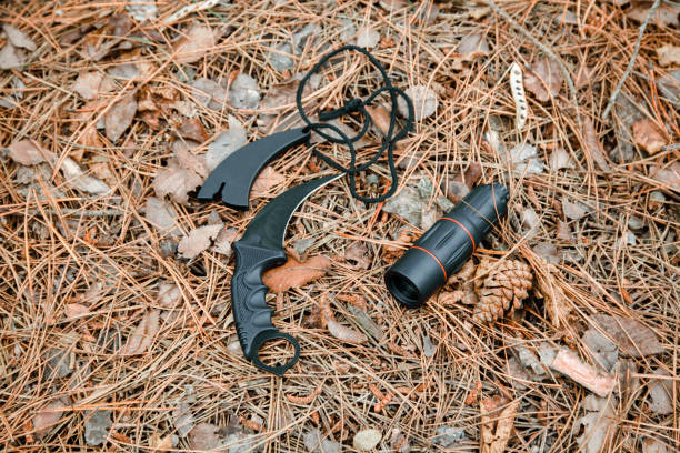 istock monocle and karambit knife on the ground covered with pine needles 1135102546