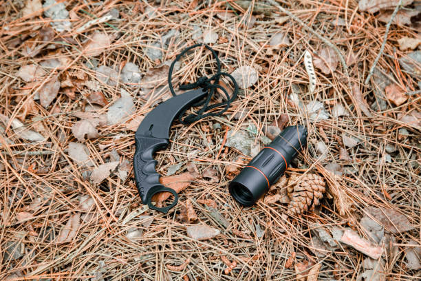 istock monocle and karambit knife on the ground covered with pine needles 1135102630