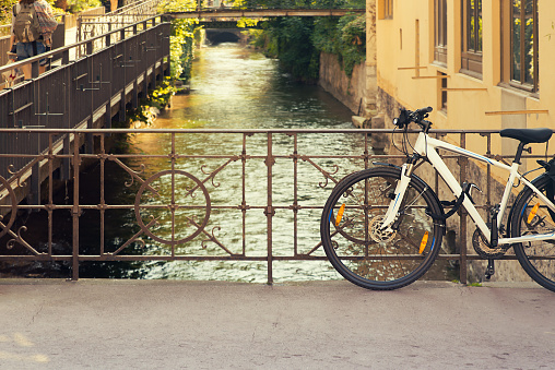 Mountain bike parked near canal in springtime -  Annecy, France