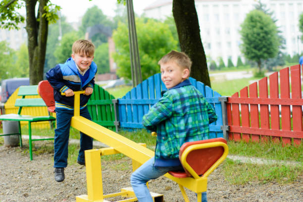 istock Funny boys swing on a yellow swing-board 1135103070