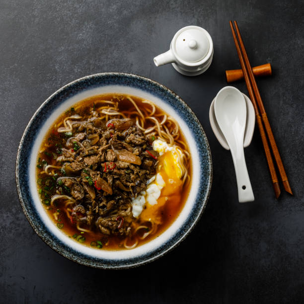 istock Ramen asian noodle in broth with minced beef meat and poached egg on dark background 1135104962