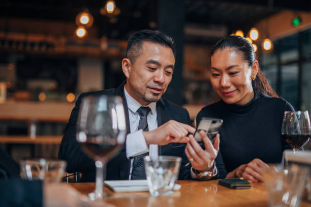 istock Man and woman using smart phone in restaurant 1135107583