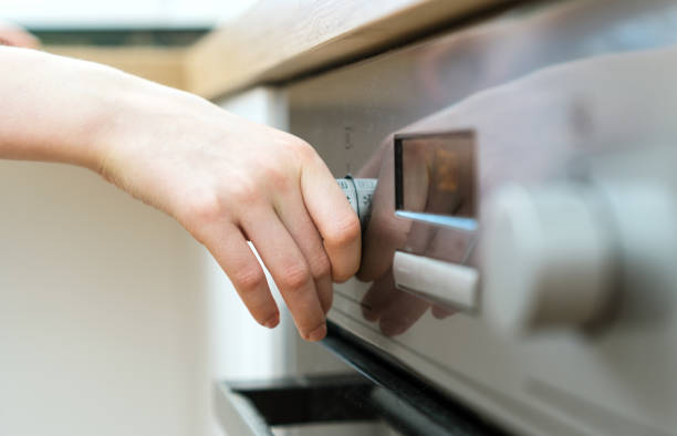 istock Dangerous situation in the kitchen. Child playing with electric oven. 1135107853
