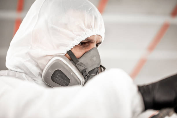 istock Professional car painter with a breathing mask and white protective hood working on a car 1135111234