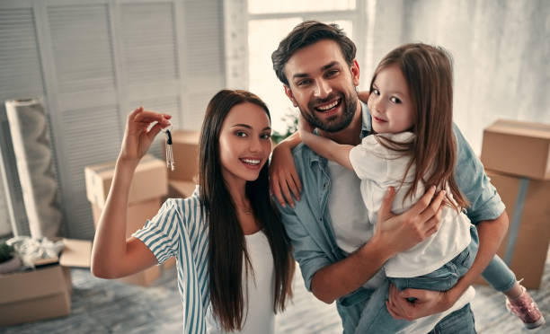 Family on moving day Family on moving day. Attractive young woman and handsome bearded man with their cute little daughter are happy to move into new home. happy family with key of their new house stock pictures, royalty-free photos & images