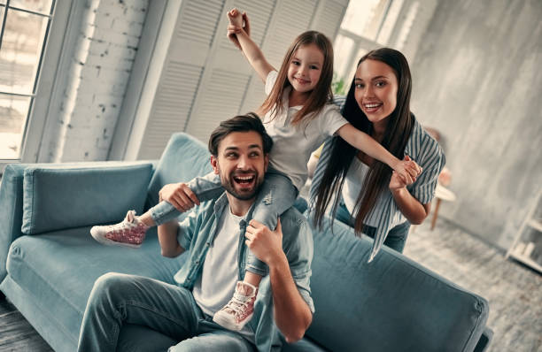 Happy family at home Happy family concept. Handsome bearded man and attractive young woman with little cute daughter are at home together. family at home stock pictures, royalty-free photos & images