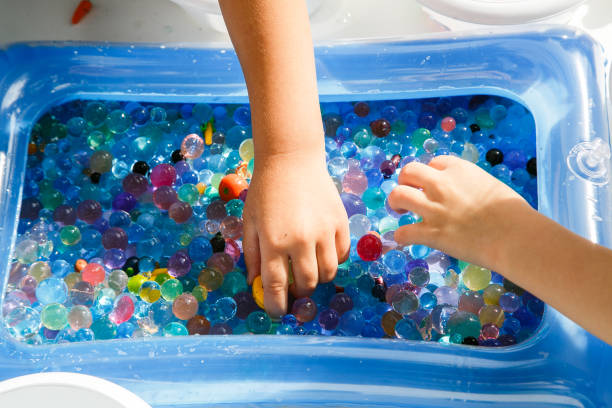 istock child playing with colored glass ball, playing game with colored balls, 1135113120