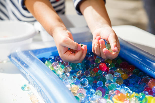 istock child playing with colored glass ball, playing game with colored balls, 1135113125