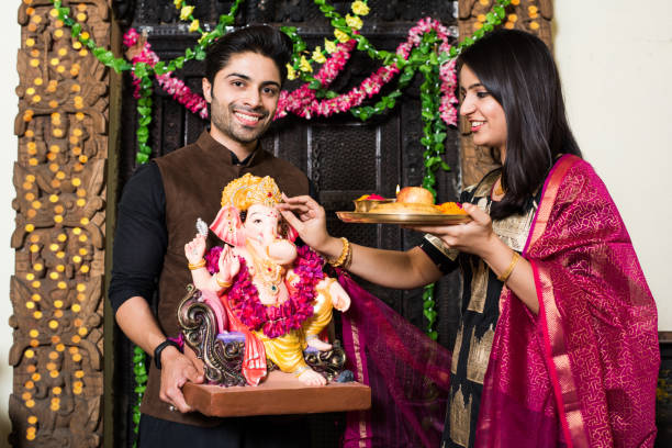 Young couple worshipping Lord Ganesha on Ganesh Festival Young couple worshipping Lord Ganesha on Ganesh Festival beautiful traditional indian girl stock pictures, royalty-free photos & images
