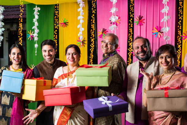 família indiana que troca/que prende caixas de presente no festival de diwali/casamento ou em toda a outra cerimónia. estando de encontro ao fundo decorado - indian culture family senior adult asian ethnicity - fotografias e filmes do acervo