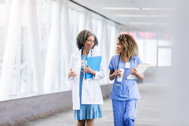Two female doctors walk down hallway together
