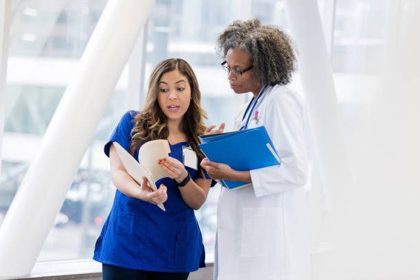 istock Medical professionals discuss patient record in hallway 1135117948