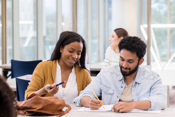 istock Young college couple study together in library 1135118154