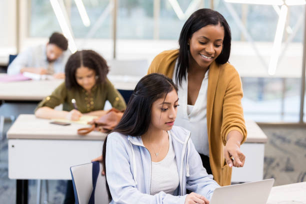 istock Young female college professor explains assignment to student 1135118163