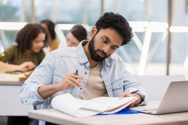 istock Young male college student studies in school library 1135118165