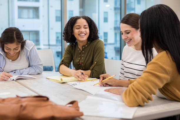 istock Young woman laughs with friends during college study group 1135118169