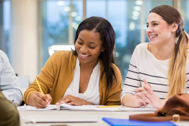 istock Young women enjoy college library study group 1135118176