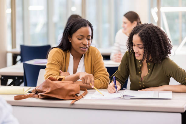 istock Two female college friends study together in library 1135118189