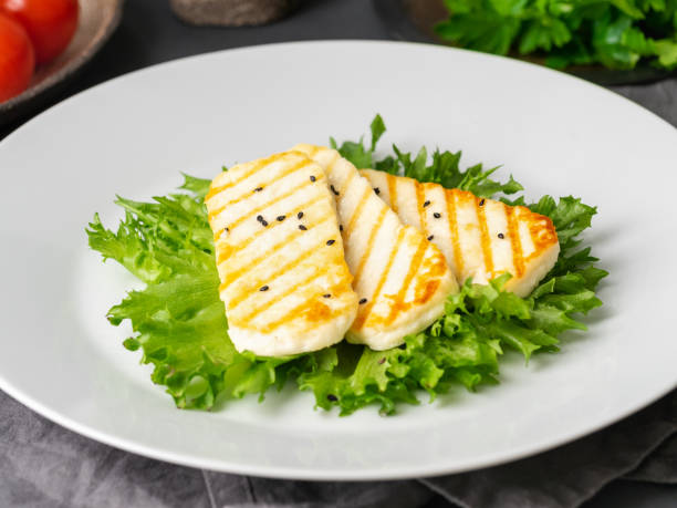 istock Grilled Halloumi, fried cheese with  lettuce salad.  Balanced diet, white plate on dark background, side view 1135118615