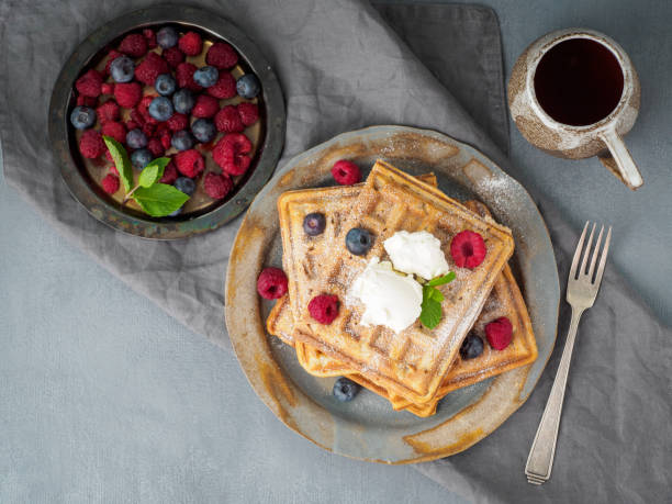 istock Belgian waffles with raspberries, chocolate syrup. Breakfast with tea on dark background, top view 1135120003
