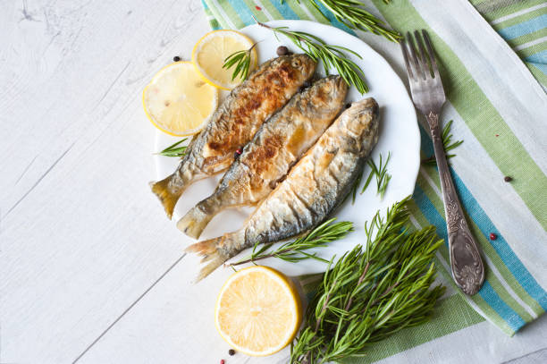 istock Fried fish with lemon rosemary and pepper. 1135121370