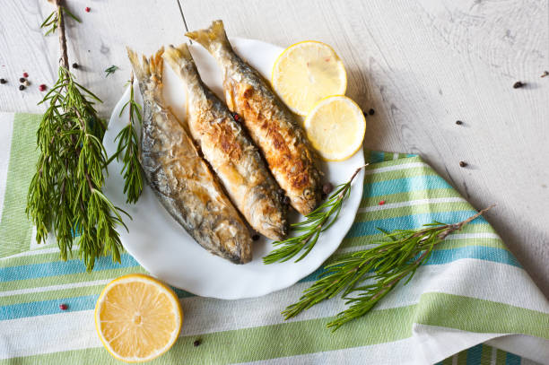 istock Fried fish with lemon rosemary and pepper. 1135121450