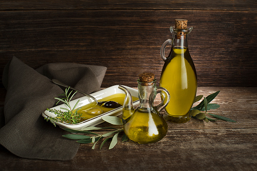 Healthy olive oil with herbs pouring in to plate close up