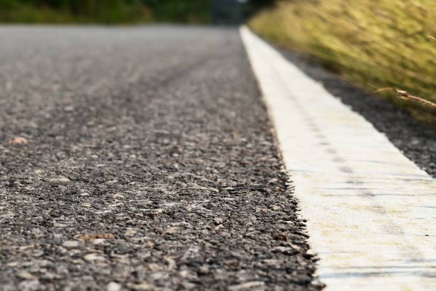 istock grass beside old and dirty white line on asphalt road 1135121904