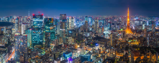 Tokyo glittering neon night Tokyo Tower skyscapers aerial panorama Japan The iconic spire of the Tokyo Tower spotlit at dusk above the illuminated urban streets and crowded cityscape of central Tokyo, Japan. dystopia concept photos stock pictures, royalty-free photos & images