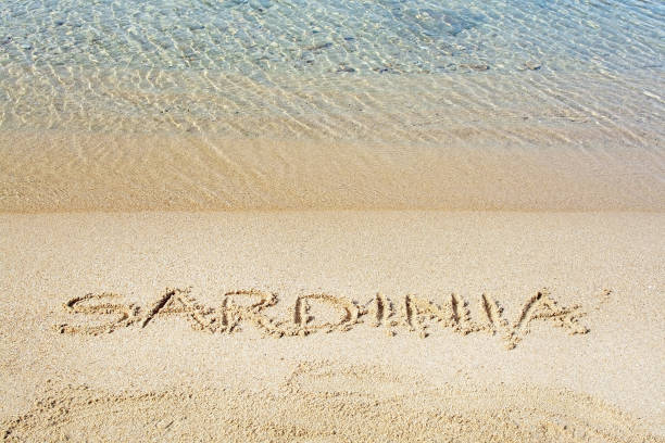 istock Sardinia word written in sand on a beach 1135124318