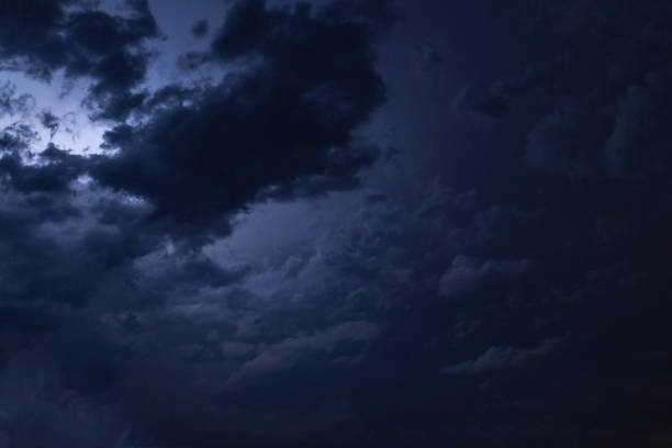 istock A flash of lightning behind the clouds in the night sky. 1135124712
