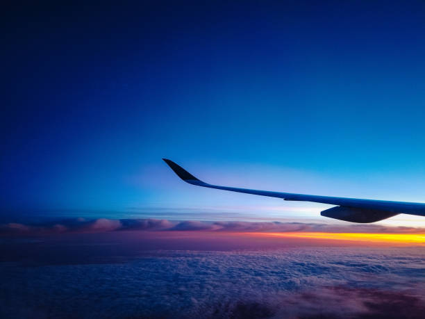 istock Airplane Wing in Flight from Window Sunrise Sky 1135125086