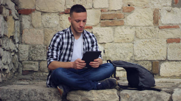istock Businessman sitting on stone and working 1135125414