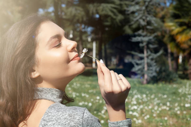 the young women smelling the flower. girl and nature