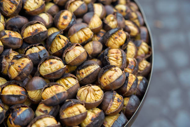 roasting chestnuts on the street in rome, italy - chestnut imagens e fotografias de stock