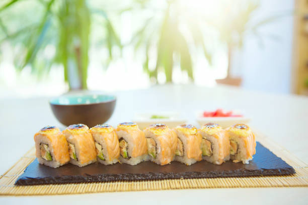 istock Maki Sushi - Roll made of Smoked Eel, Cream Cheese and Deep Fried Vegetables inside. Fresh Salmon outside 1135128392
