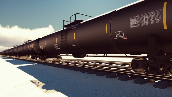 The camera flies past the railroad with cisterns passing through it with oil.